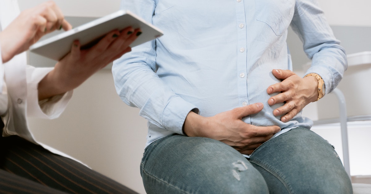 pregnant women puts hands on her baby bump